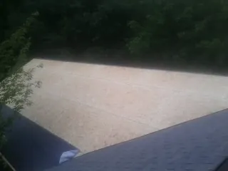 New OSB roof sheathing installed beside an existing shingle roof in Mahaffey