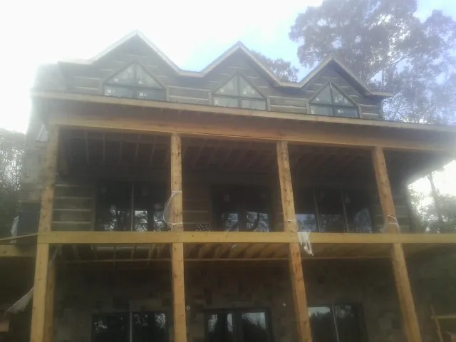 Dormers and porch framing on a large log home under construction — Roof Coating work by our crew in Mahaffey