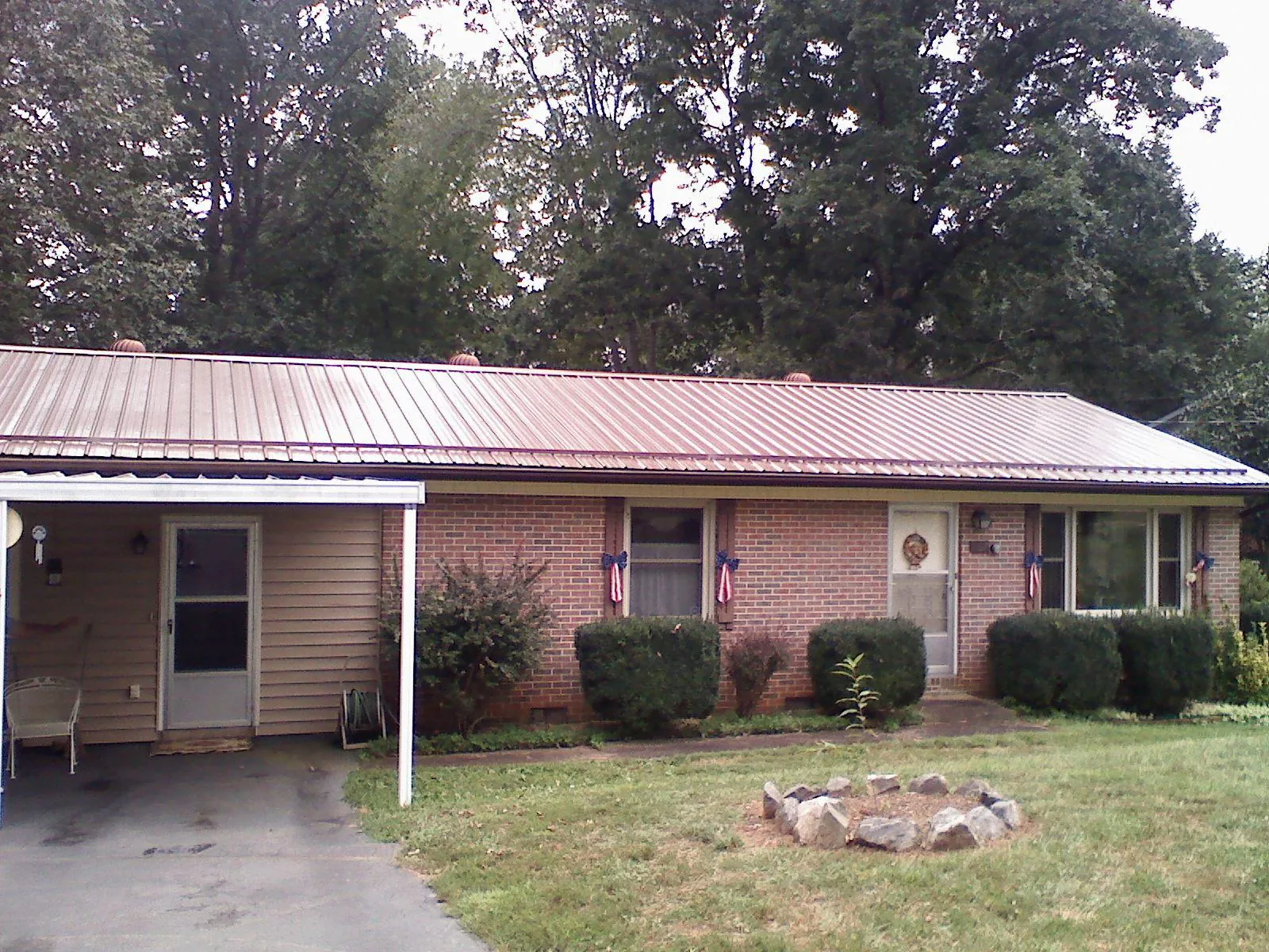 Bronze metal roof and carport on a brick ranch home — Roof Repair work by our crew in Mahaffey